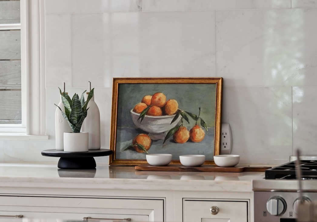 A minimally styled kitchen with marble backsplash and restrained accessories that highlight balance and calm.
