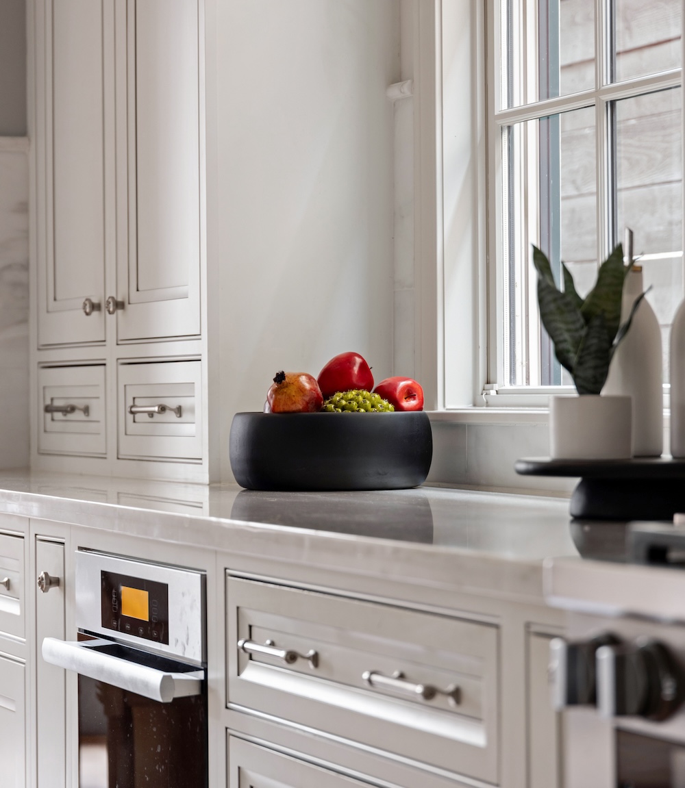 A quiet luxury kitchen styled with a sculptural matte vessel, demonstrating how shape, scale, and contrast create balance without relying on decoration.