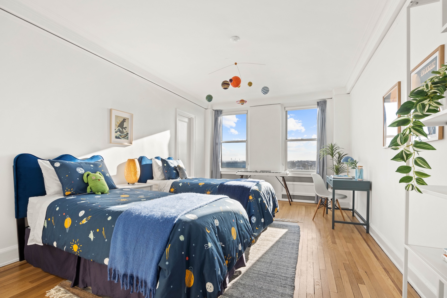 Professionally staged Brooklyn bedroom at Prospect Park West with twin beds, space-themed bedding, and natural light.